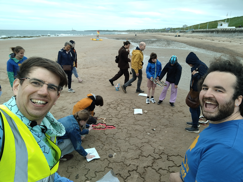 A selfie with two volunteers smiling at the camera, with the tiling in the background.