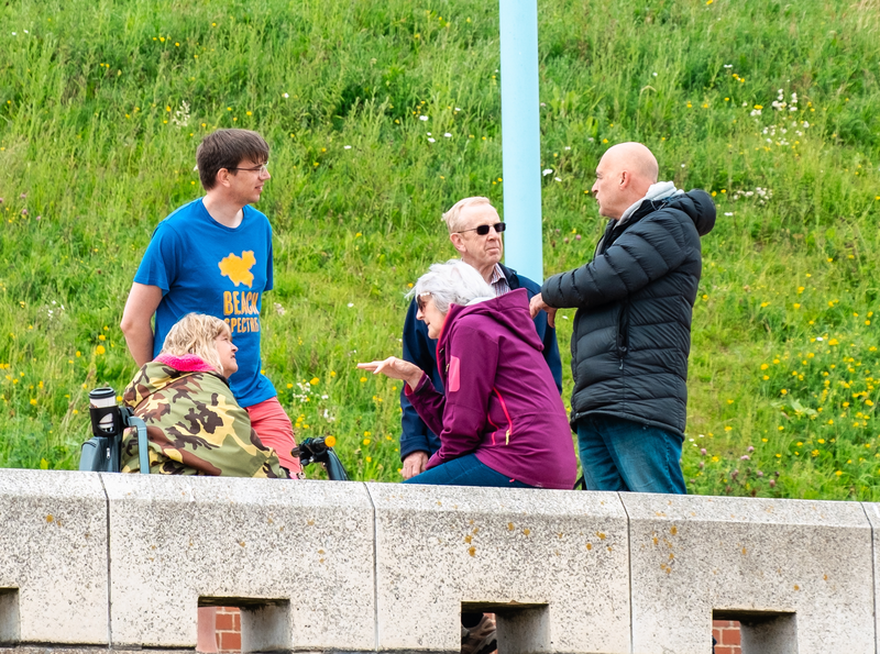 A volunteer stood on the prom, talking with a group of four people.