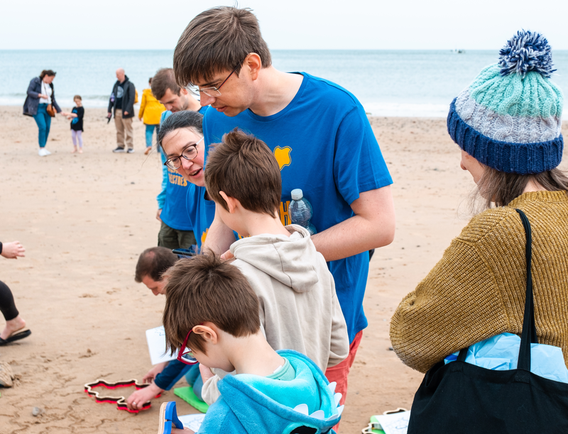 A volunteer standing with two children.