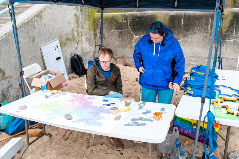 Katie and Paul looking at the map, with materials piled on the table next to them.