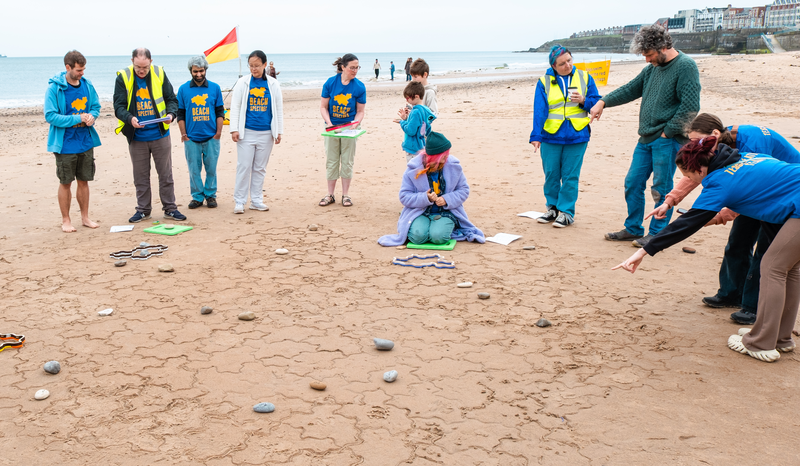 People gathered on the edge of the tiling. Some are pointing at an area to be filled in.